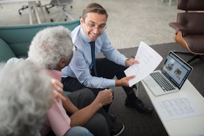 A senior couple discussing life insurance options with a financial advisor, representing financial security and planning for life insurance needs at 60."